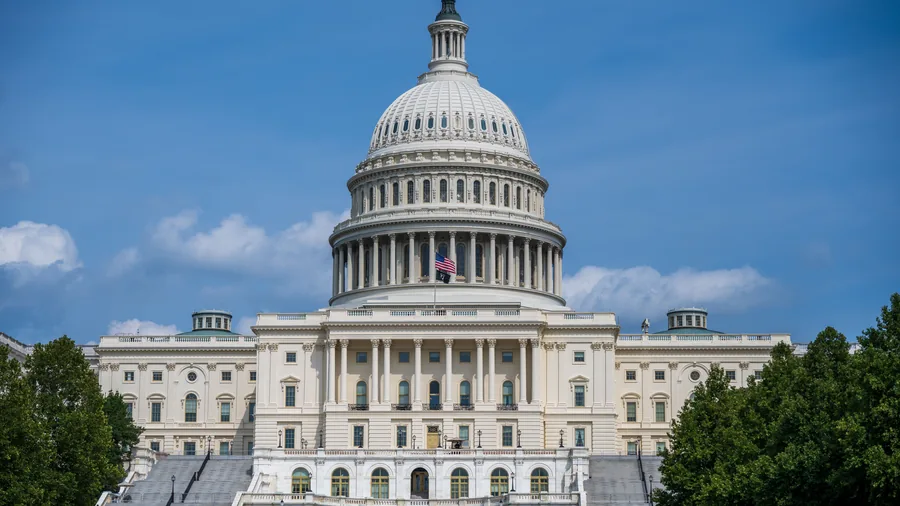 Het Capitool in Washington met de witte koepel en de trappen aan de voorkant onder een blauwe lucht met wolken