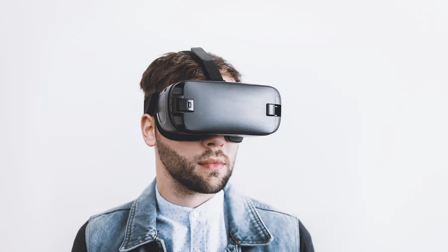 Man met een VR bril op tegen een lichte achtergrond