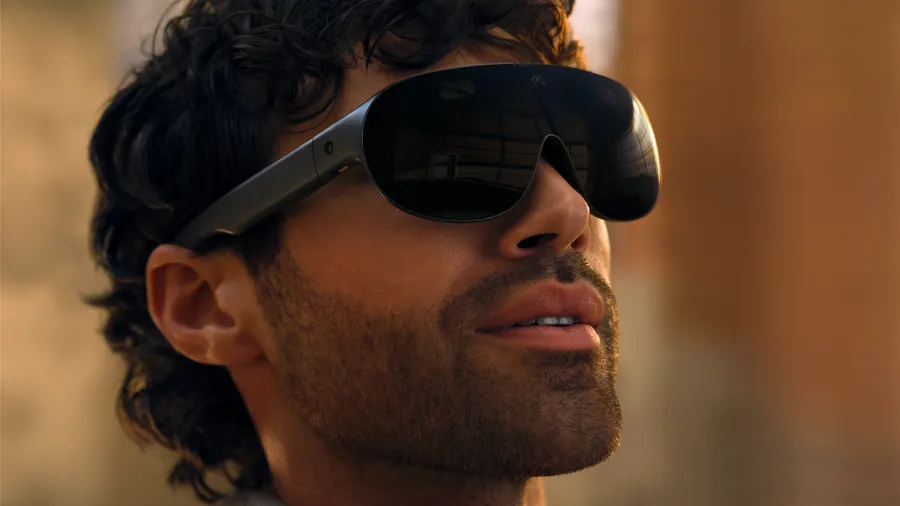 Man draagt de Meta VR Glasses, een dunne VR bril met donkere glazen, in het zonlicht
