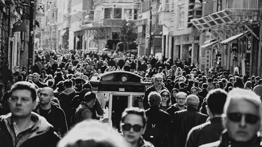 Zwart-witfoto van een drukke straat vol voetgangers, van wie een paar een zonnebril dragen