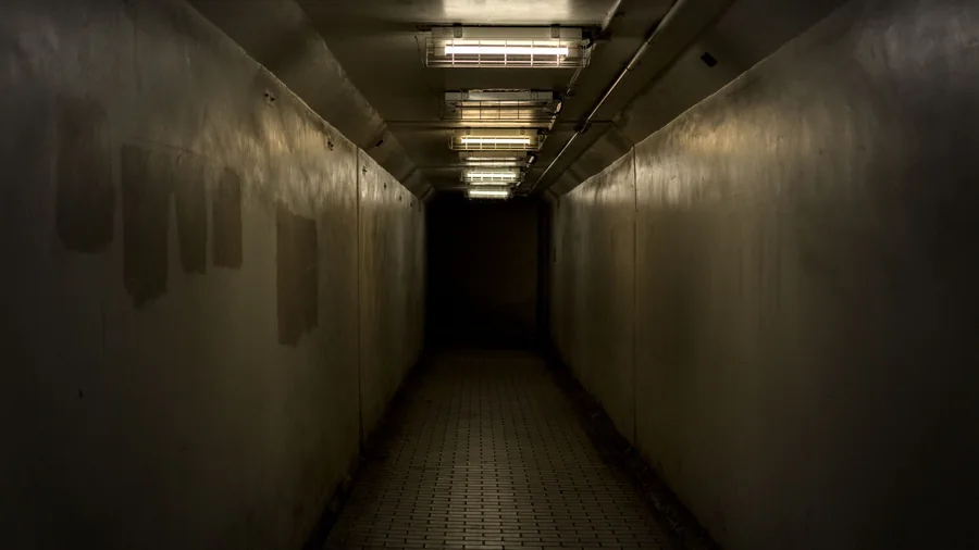 Donkere lege gang met een rij tl-lampen aan het plafond